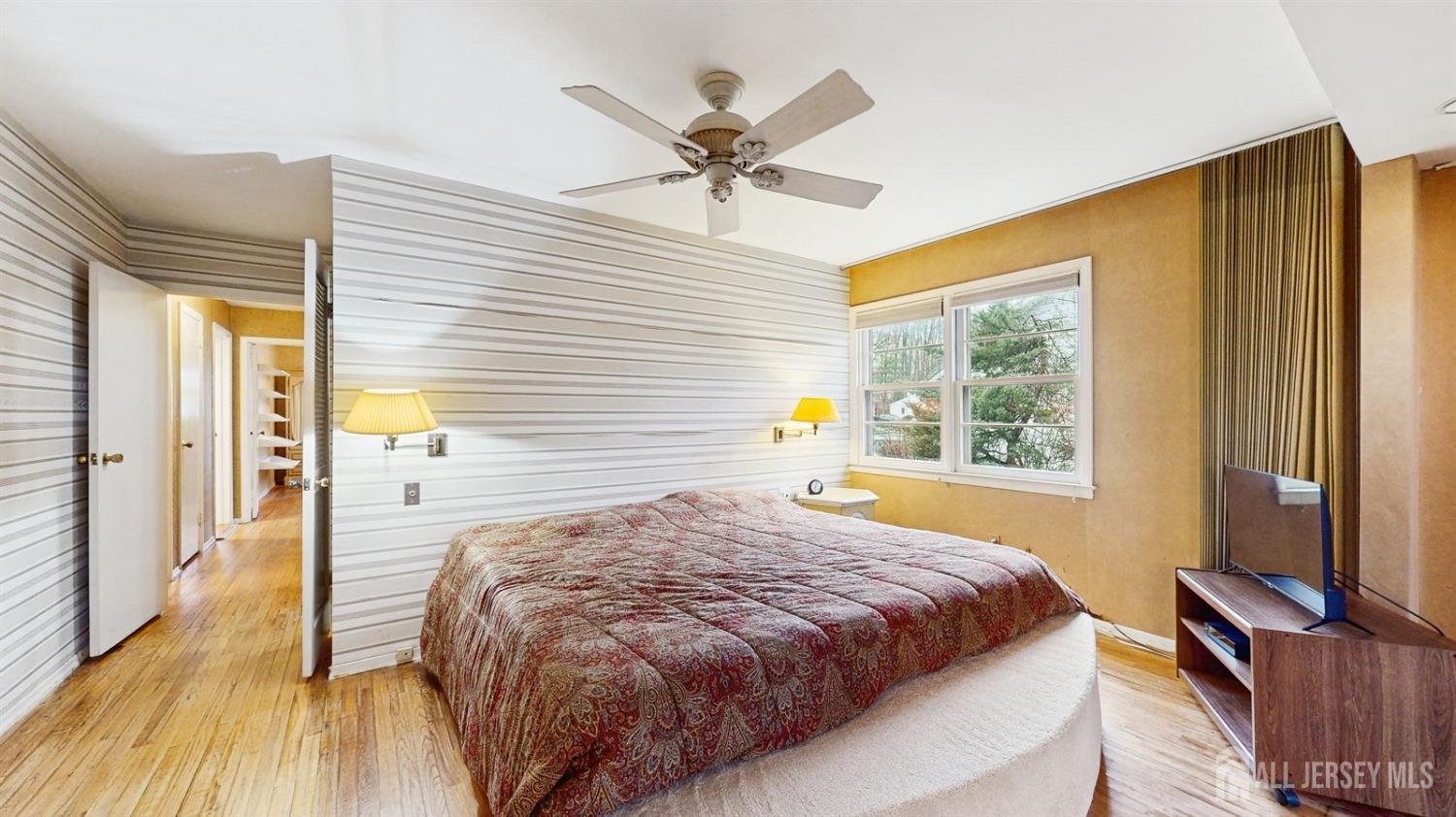 4 Whitewood Road Edison, NJ 08820 - Photo 15 of 31 a bedroom with a bed and a chandelier with a flat tv screen