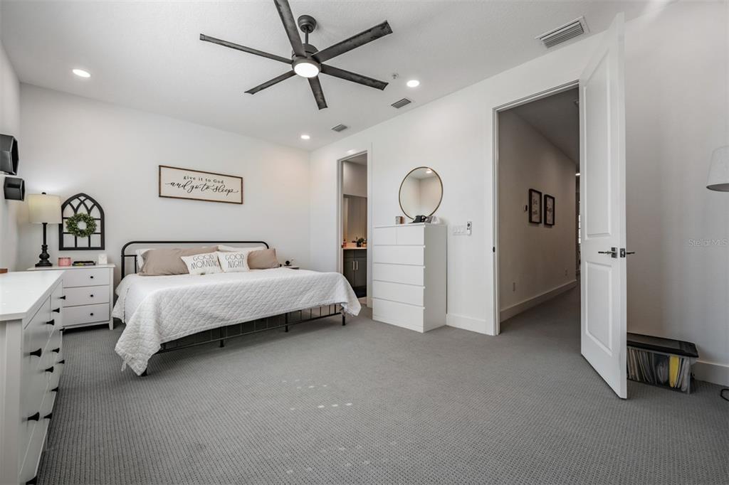 9916 Key Haven Road Seminole, FL 33777 - Photo 16 of 40 a spacious bedroom with a bed and a chandelier