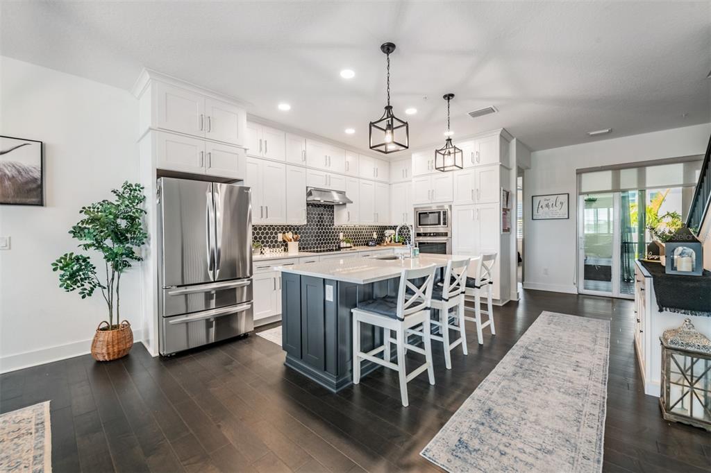 9916 Key Haven Road Seminole, FL 33777 - Photo 7 of 40 a kitchen with stainless steel appliances kitchen island granite countertop a refrigerator and a stove top oven