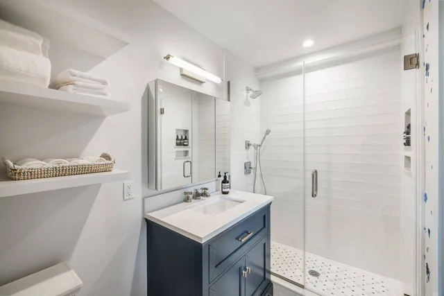 a bathroom with a sink a toilet and shower