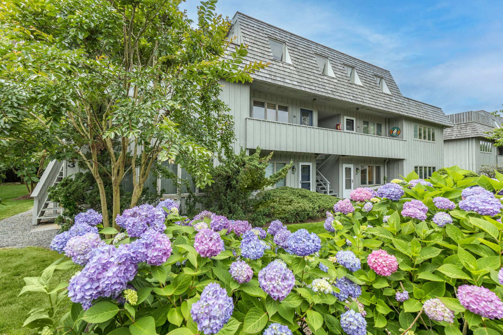 18 Bridge Street, Unit 3E Sag Harbor, NY 11963 - Photo 20 of 22 a front view of white house with flowers