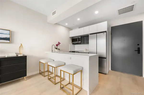 a kitchen with stainless steel appliances kitchen island granite countertop a refrigerator and a stove top oven