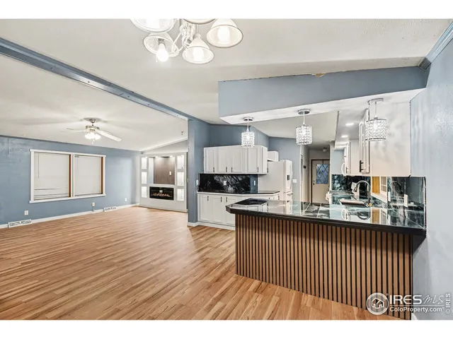 a open kitchen with a sink and dishwasher with wooden floor