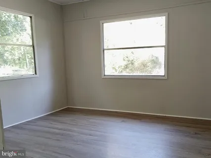 an empty room with wooden floor and a window