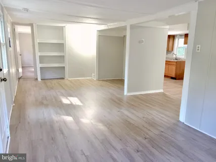 a view of empty room with wooden floor