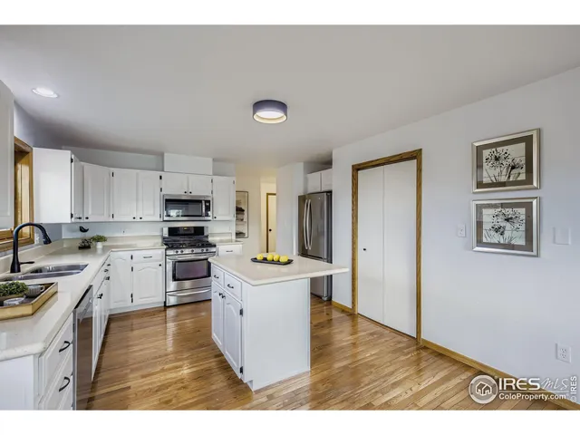 a kitchen with a refrigerator a stove top oven and white cabinets