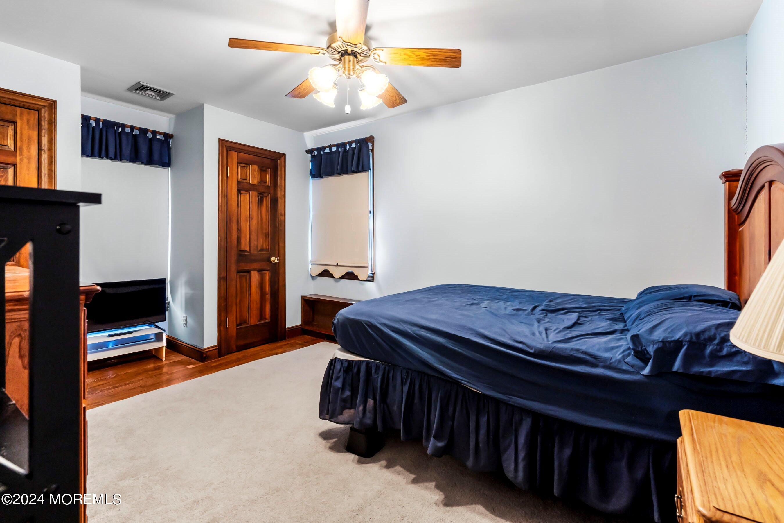 14 Deerpath Lane Colts Neck, NJ 07722 - Photo 24 of 32 a bed room with a bed and a chandelier