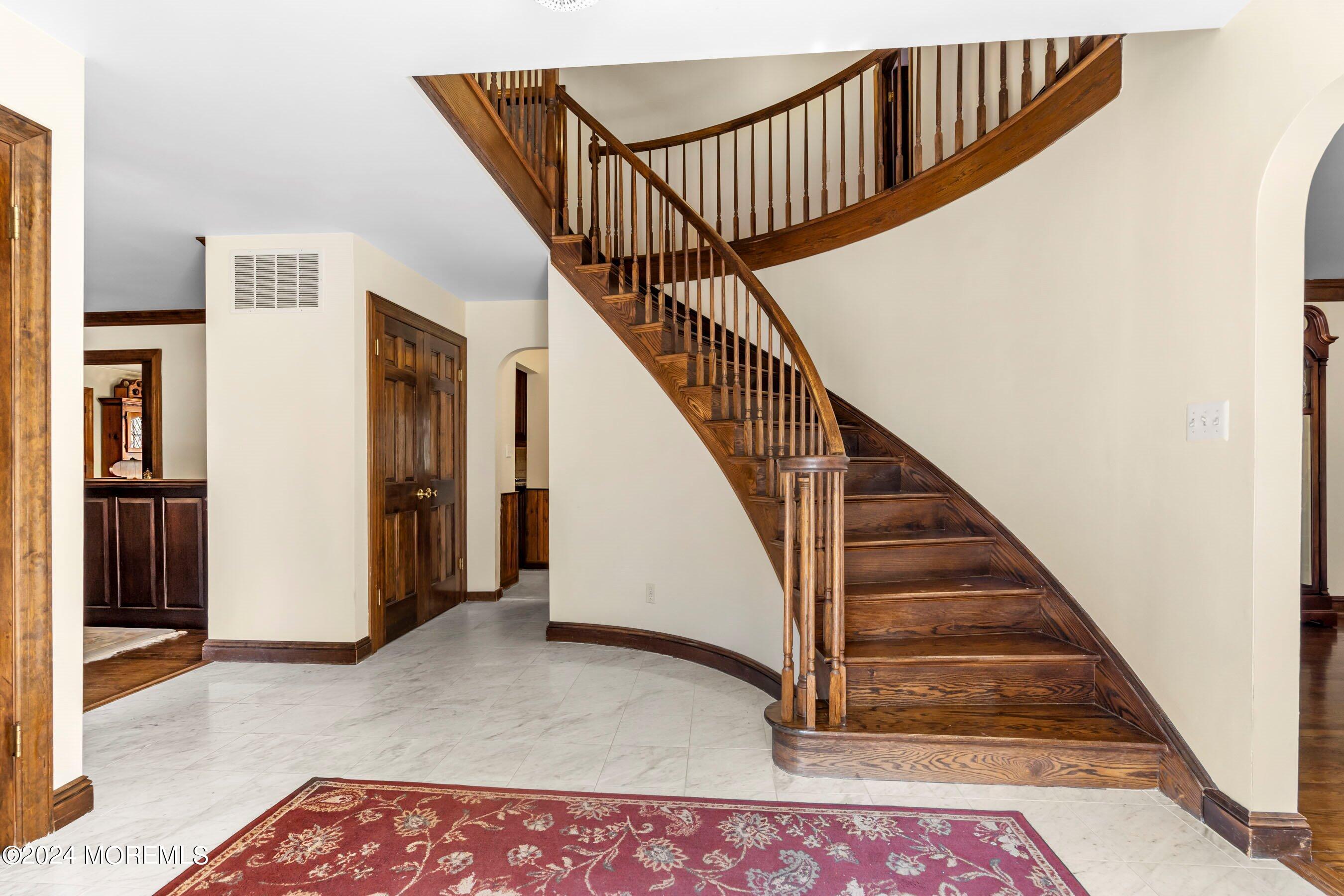 14 Deerpath Lane Colts Neck, NJ 07722 - Photo 6 of 32 a view of staircase with lots of frames on wall and wooden floor