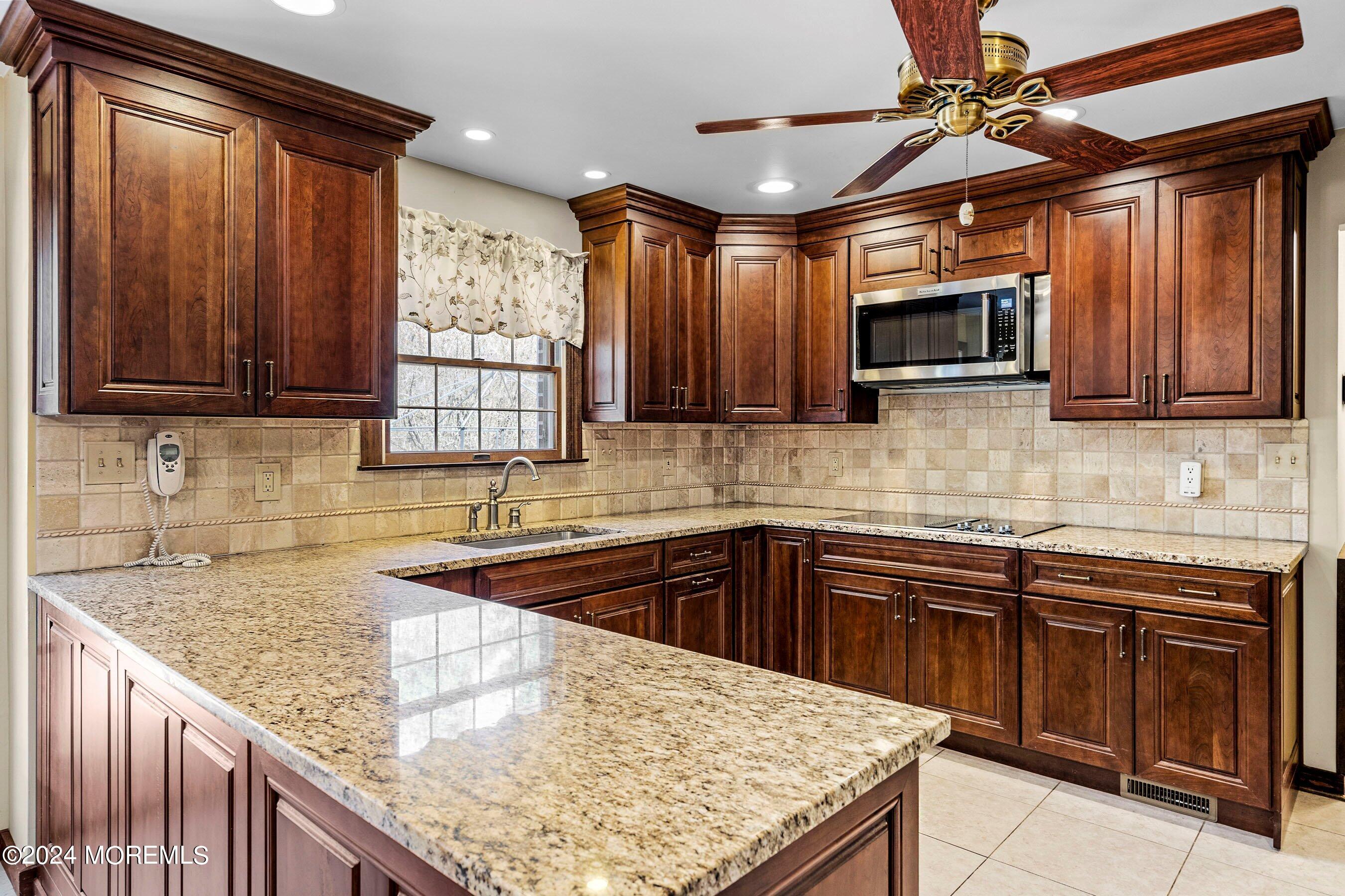 14 Deerpath Lane Colts Neck, NJ 07722 - Photo 10 of 32 a kitchen with stainless steel appliances granite countertop wooden cabinets a sink and a counter top space