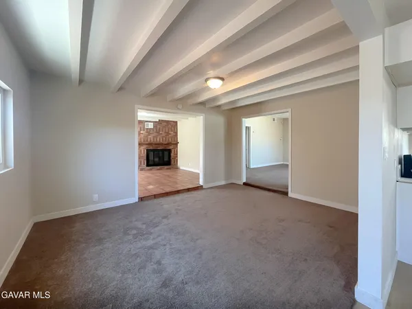 an empty room with windows and fireplace
