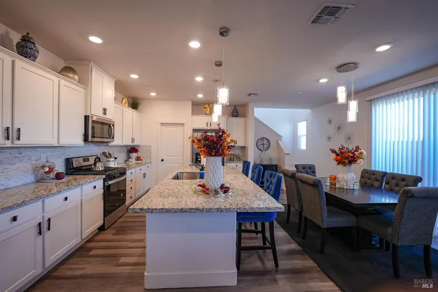 a large kitchen with kitchen island a sink table and chairs