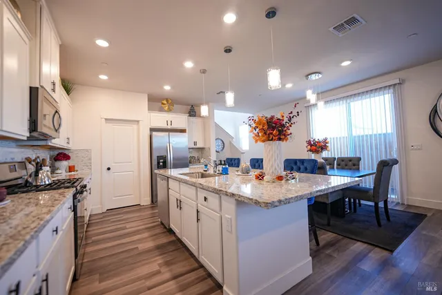 a kitchen with stainless steel appliances granite countertop sink stove and wooden cabinets