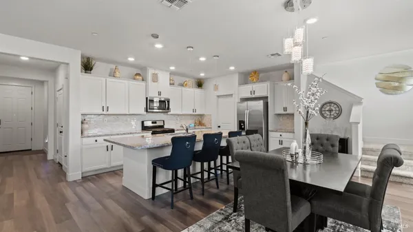 a large kitchen with cabinets table and chairs