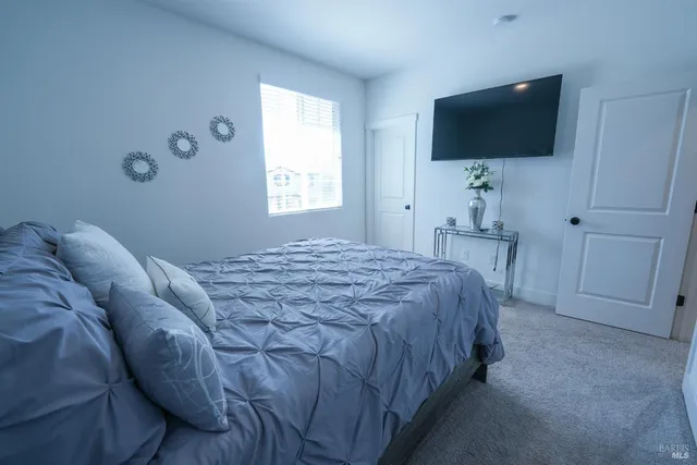a bedroom with a bed and a flat screen tv
