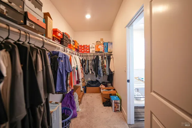 a view of walk in closet with clothes