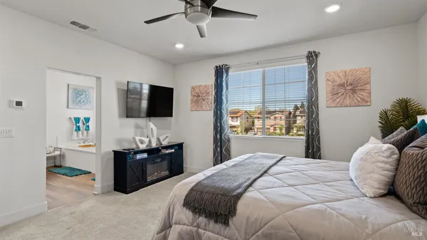 a bedroom with a bed flat screen tv and a window