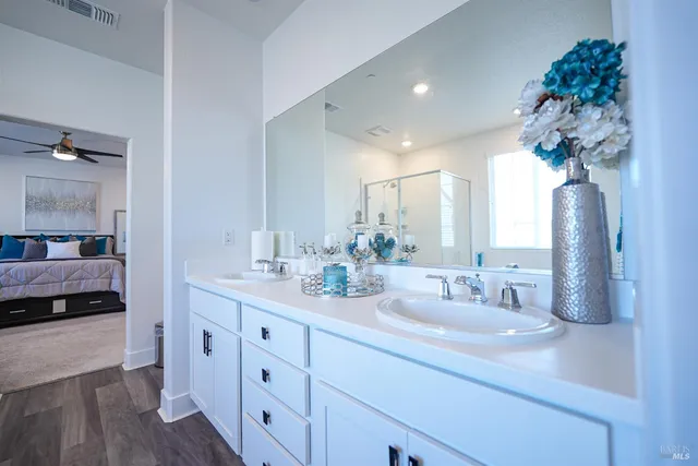 a en suite bathroom with a double vanity sink and a mirror