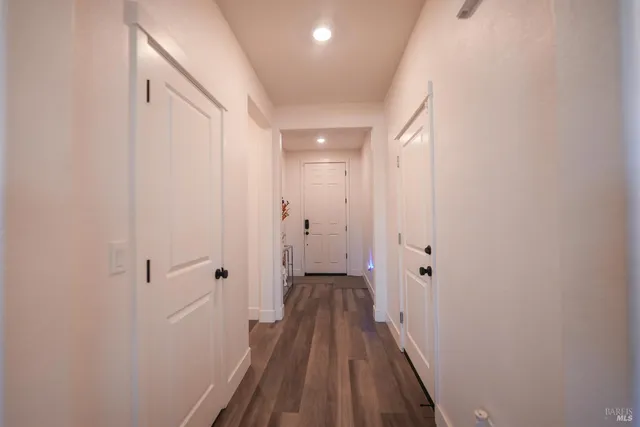 a view of a room with wooden floor and a bathroom
