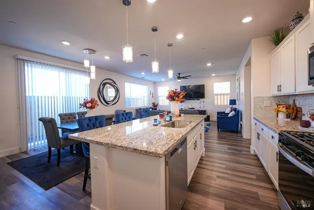 a large kitchen with kitchen island a island a sink a stove and a wooden floors
