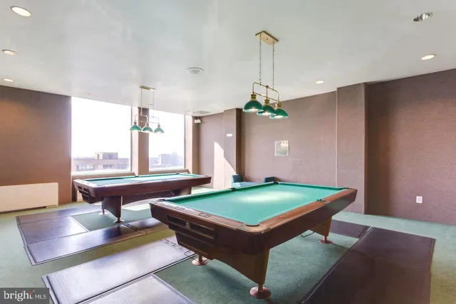 a room with pool table and windows