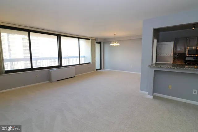 an empty room with a fireplace and large window