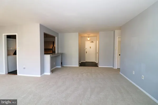a view of empty room with kitchen