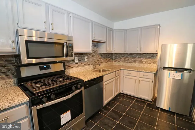 a kitchen with cabinets and steel stainless steel appliances