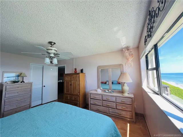 a bathroom with a granite countertop sink a mirror a toilet and a shower