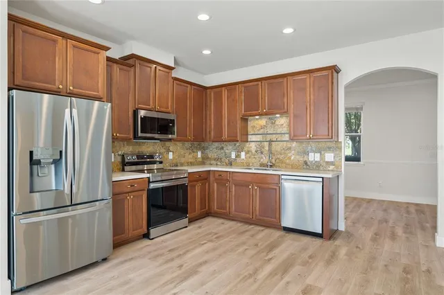 a kitchen with granite countertop stainless steel appliances and wooden cabinets