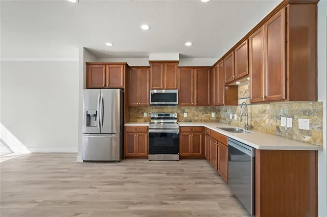 a kitchen with stainless steel appliances granite countertop a refrigerator stove top oven and sink