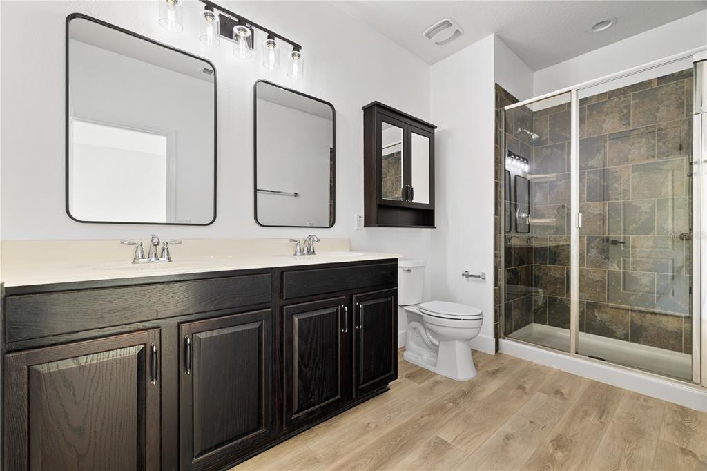 7819 Hardenton Street Windermere, FL 34786 - Photo 41 of 48 a bathroom with a double vanity sink toilet and shower