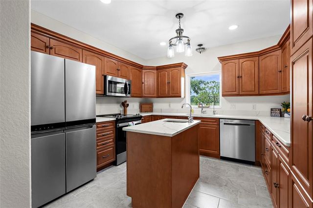 a kitchen with stainless steel appliances granite countertop a refrigerator stove top oven a sink and dishwasher