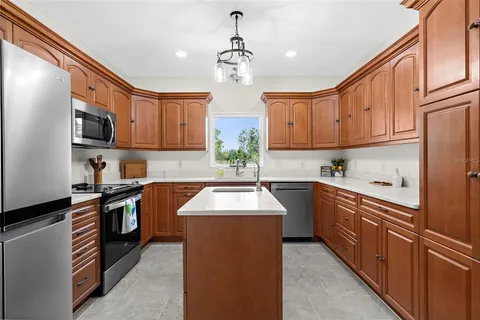 a kitchen with stainless steel appliances granite countertop a sink stove and refrigerator