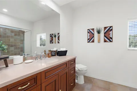 a bathroom with a granite countertop sink a toilet and a mirror