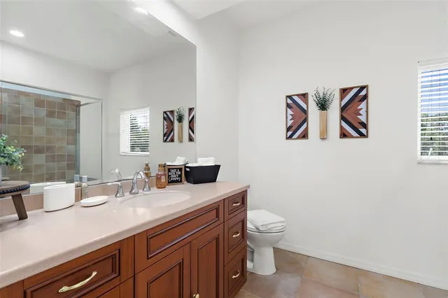 a bathroom with a granite countertop sink a toilet and a mirror