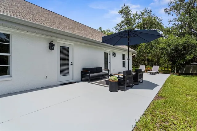a view of a patio with couches table and chairs and a umbrella
