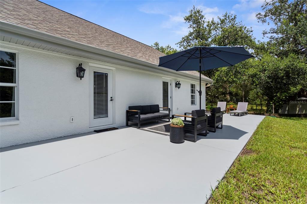 18355 Highway 62 Parrish, FL 34219 - Photo 37 of 50 a view of a patio with couches table and chairs and a umbrella