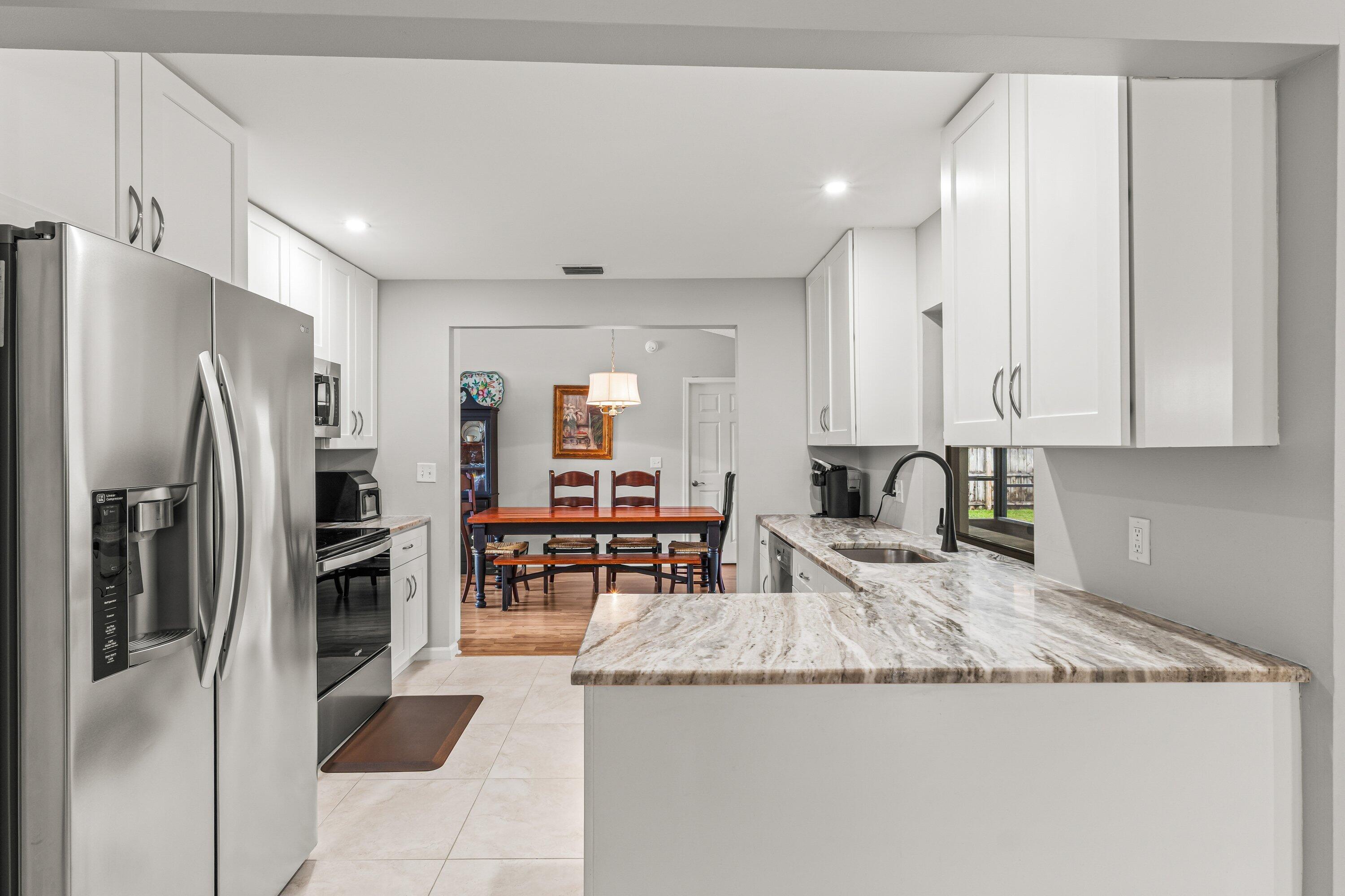 13795 Geranium Place Wellington, FL 33414 - Photo 11 of 37 a kitchen with stainless steel appliances granite countertop a refrigerator and a stove