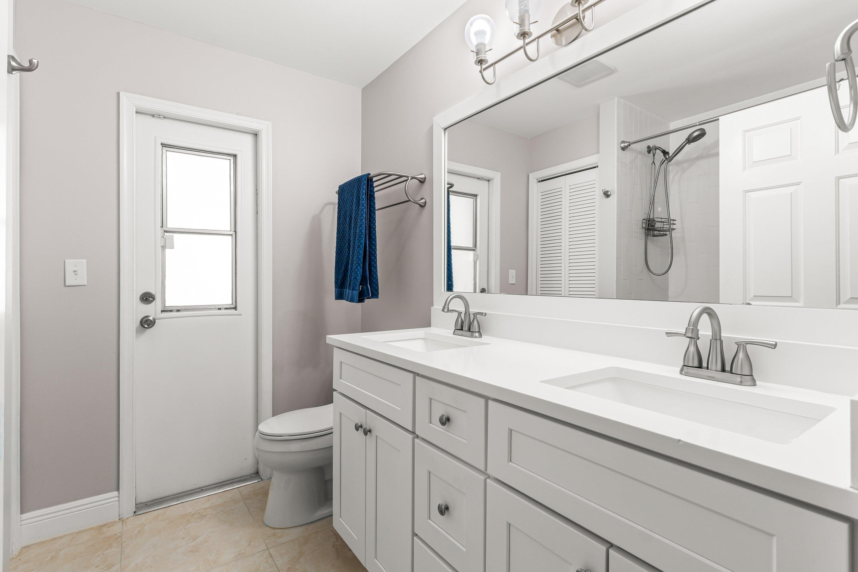 13795 Geranium Place Wellington, FL 33414 - Photo 14 of 37 a bathroom with a toilet a sink a mirror and vanity