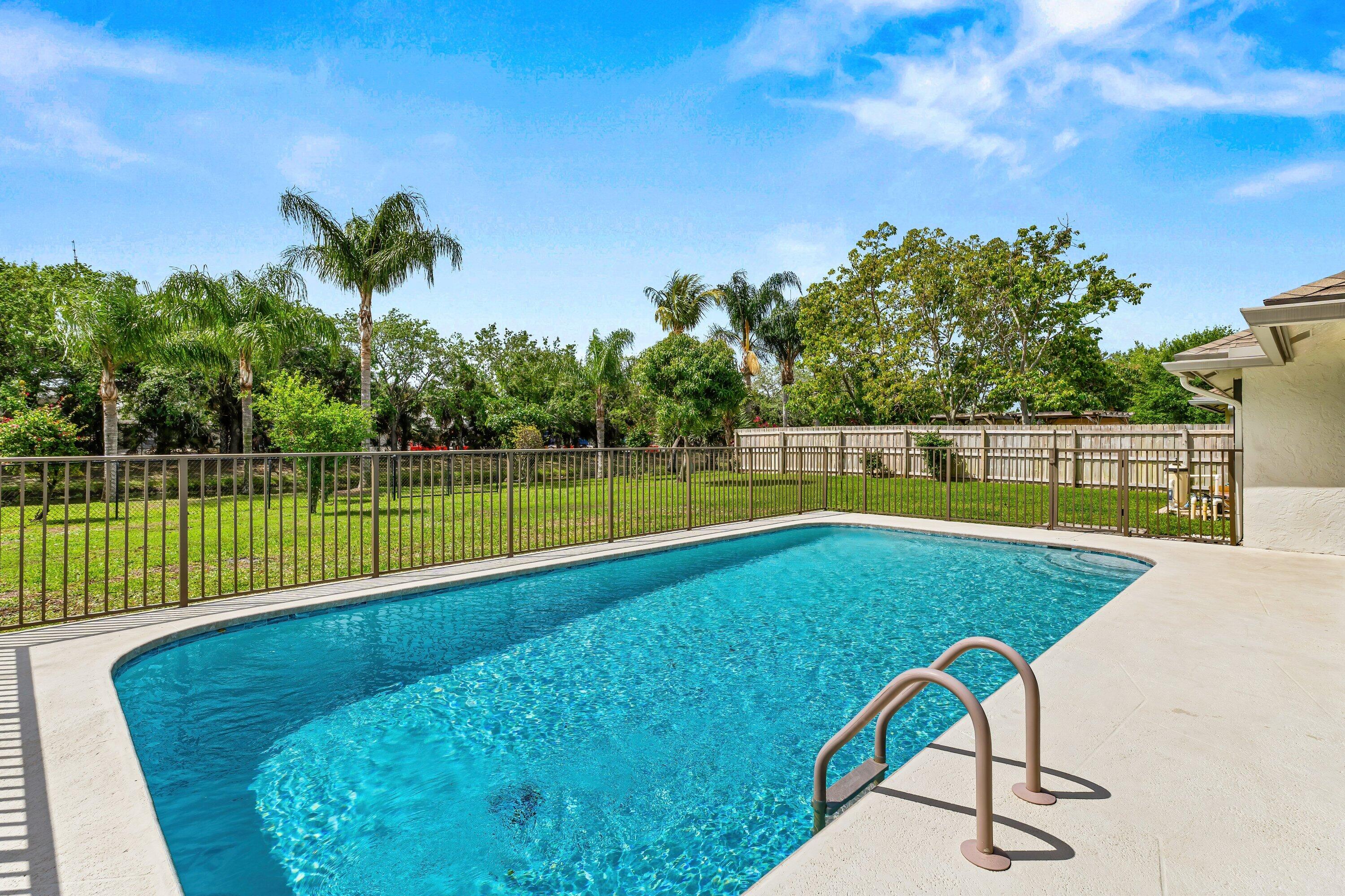 13795 Geranium Place Wellington, FL 33414 - Photo 26 of 37 a view of a swimming pool with a patio and a garden