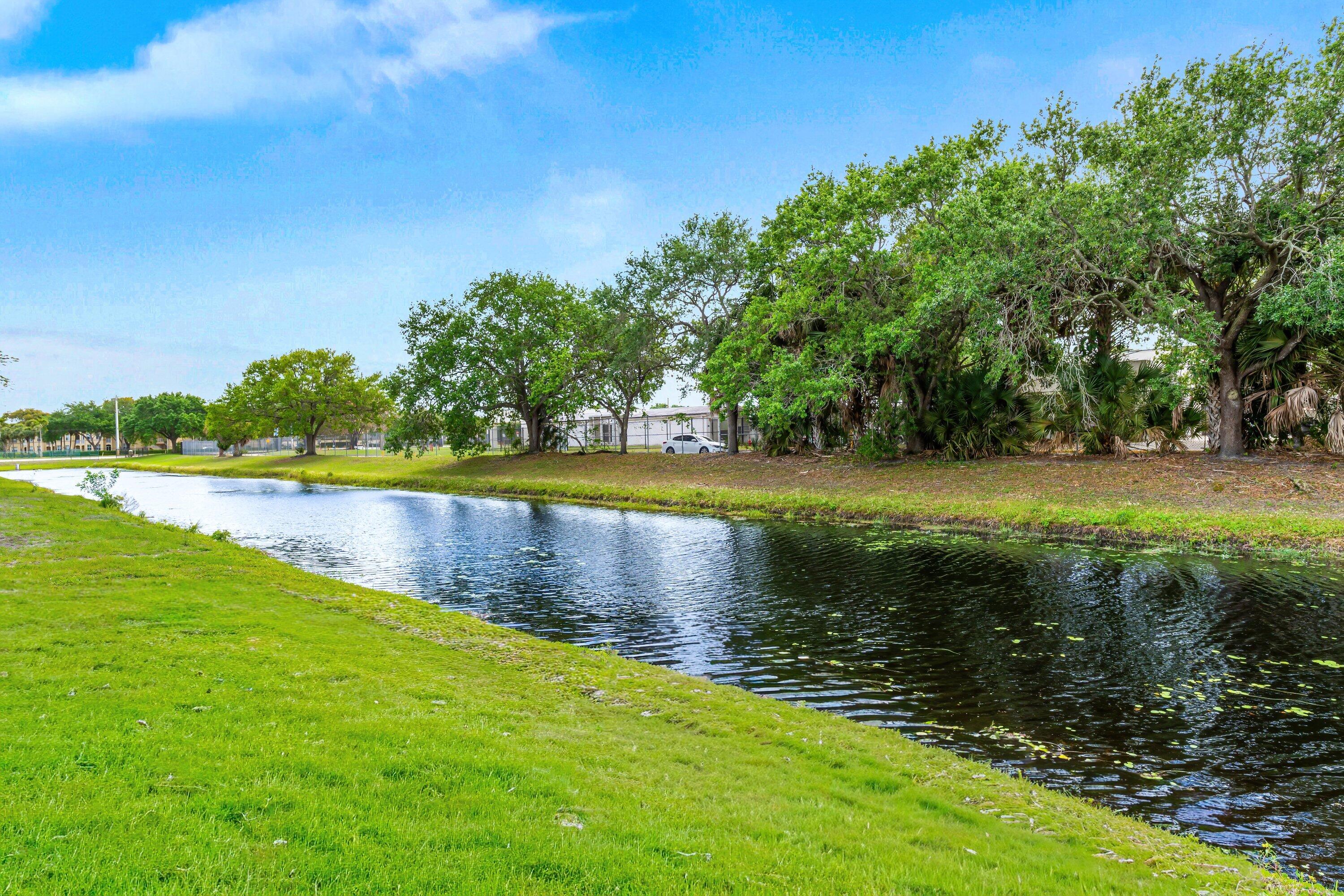 13795 Geranium Place Wellington, FL 33414 - Photo 28 of 37 a view of a lake with houses in the background
