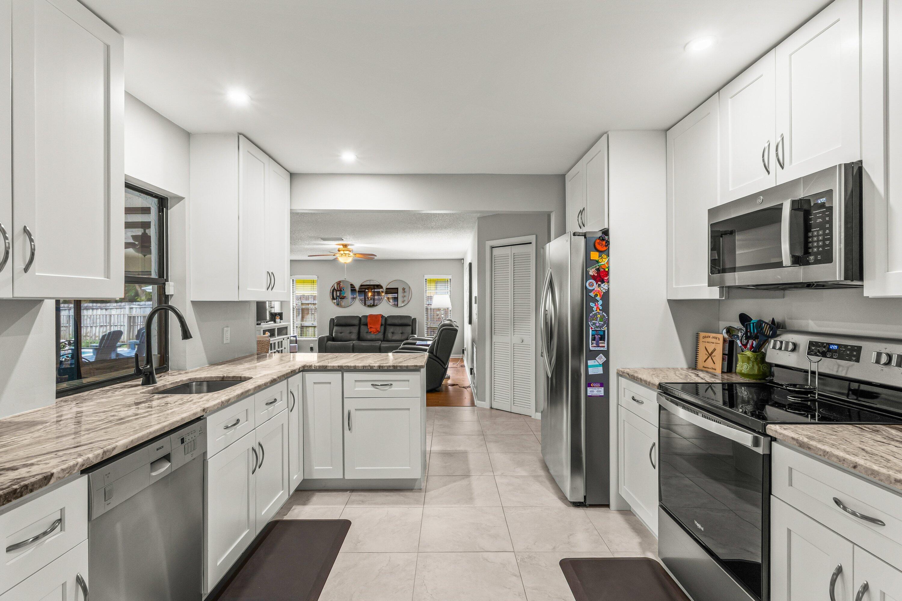 13795 Geranium Place Wellington, FL 33414 - Photo 5 of 37 a kitchen with stainless steel appliances granite countertop a refrigerator sink and stove