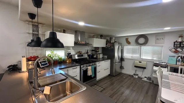 a kitchen with stainless steel appliances granite countertop a stove and a sink