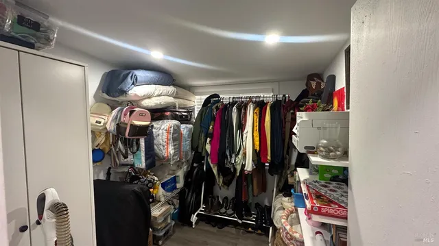a view of walk in closet with clothes and shoes