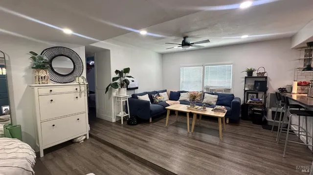 a living room with furniture a flat screen tv and a window