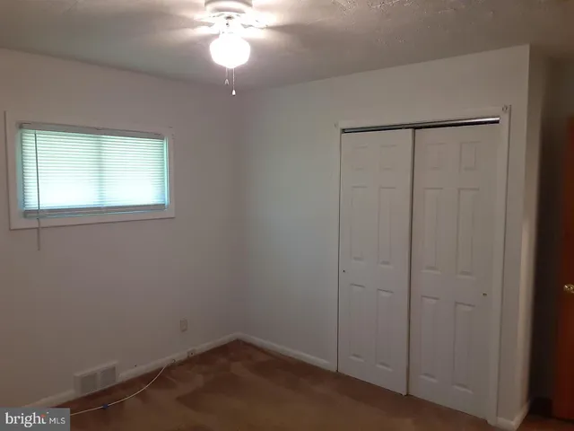 an empty room with a chandelier fan