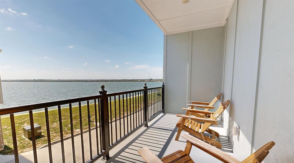 602 Winners Circle Rowlett, TX 75088 - Photo 1 of 35 Covered balcony off the Master Bedroom, featuring a metal railing and expansive water frontage