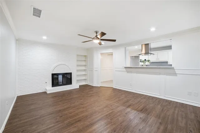 a view of empty room with wooden floor and fireplace