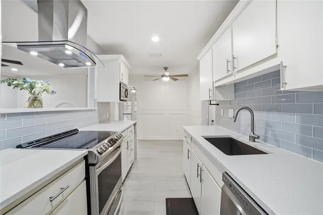 a kitchen with stainless steel appliances granite countertop a sink a stove and a refrigerator