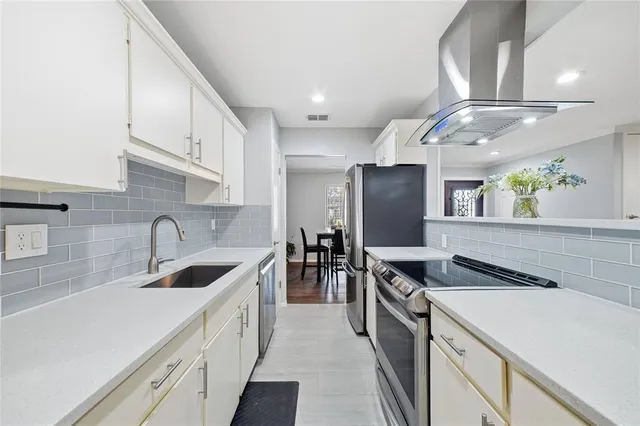 a kitchen with stainless steel appliances granite countertop a sink and a refrigerator